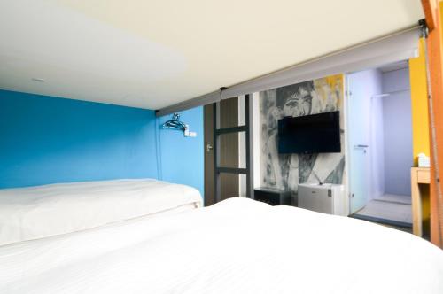 a bedroom with two beds and a blue wall at Arch Inn in Hualien City