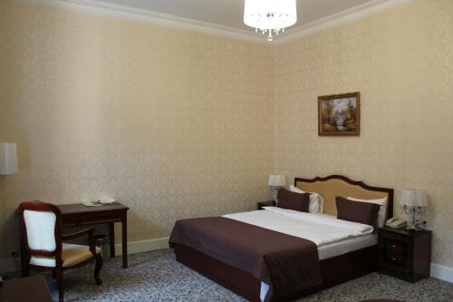a bedroom with a bed and a desk and a chair at Astrakhanskaya Hotel in Astrakhan