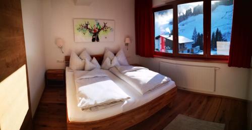 a bedroom with a large white bed with a window at Appartement Bella Vista in Bad Kleinkirchheim