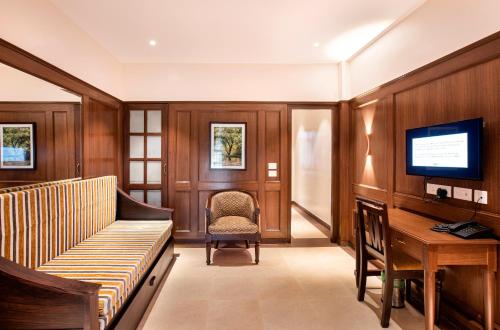 a living room with a couch and a desk and a television at Hotel Raindrops in Kodaikānāl