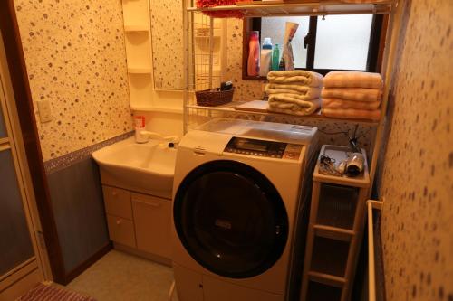 uma máquina de lavar roupa na casa de banho com um lavatório em Pop Culture House em Takayama