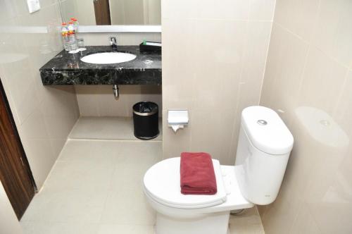 uma casa de banho com um WC branco e um lavatório. em Atrium Premiere Hotel Yogyakarta Ambarukmo em Yogyakarta