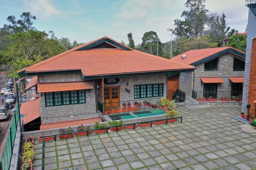a house with a red roof and a patio at Hotel Raindrops in Kodaikānāl