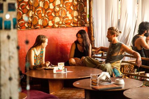 un groupe de personnes assises autour d'une table dans un restaurant dans l'établissement This is it Beachfront - Rooms, Cafe & Events, à Arambol