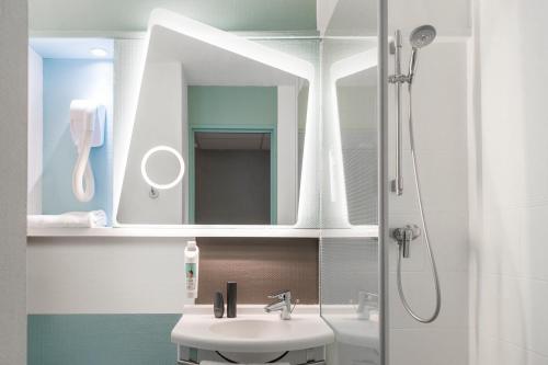La salle de bains est pourvue d'un lavabo et d'un miroir. dans l'établissement ibis Longwy Mexy, à Mexy