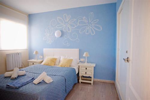 a bedroom with a blue wall with flowers on it at Sea Front Voramar fibra WiFi in Calpe