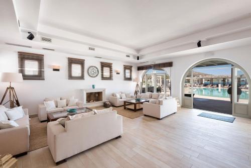 a living room with white furniture and a fireplace at Saint Andrea Seaside Resort - Adults Only in Naousa