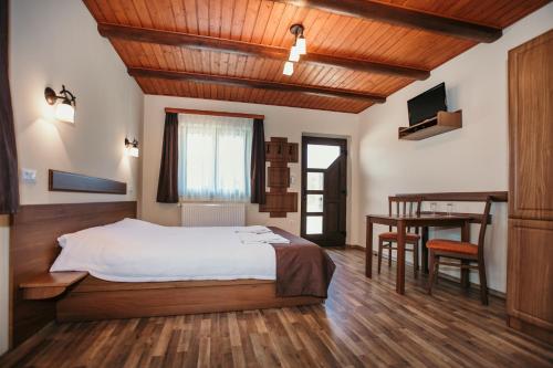 a bedroom with a bed and a desk and a table at Complex turistic Han Pescaresc in Nyàradremete