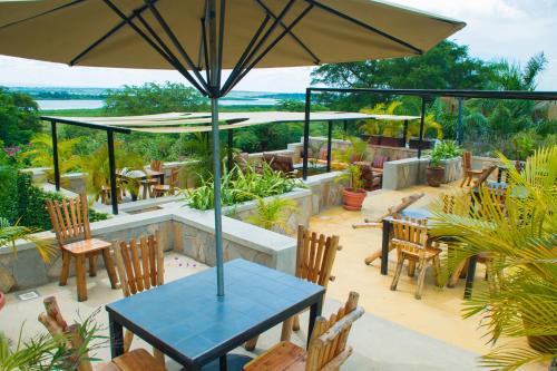 a patio with a table and chairs and an umbrella at Fort Murchison Lodge by NATURE LODGES LTD in Pakwach East