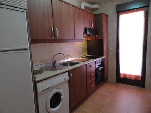 una cocina con fregadero y lavadora en Hotel Rural El Valle, en Rascafría