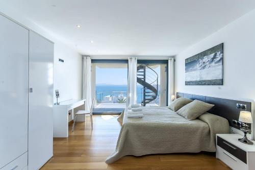 a bedroom with a bed and a view of the ocean at YupiHome Villa Aqua in Alcudia