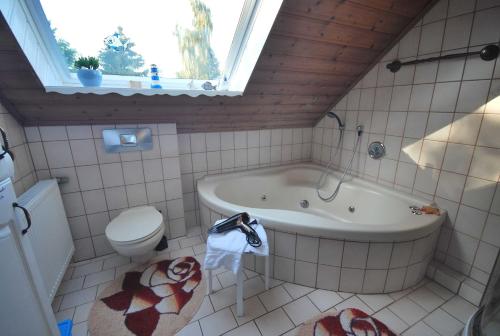 a bathroom with a tub and a toilet and a sink at Ferienwohnung Am Moor, 35629 in Uplengen