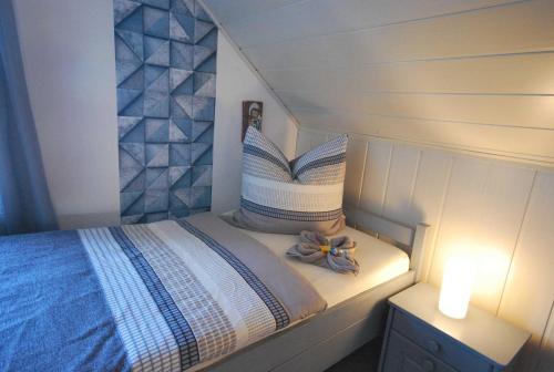 a small bedroom with a bed with a flower on it at Ferienwohnung Am Moor, 35629 in Uplengen