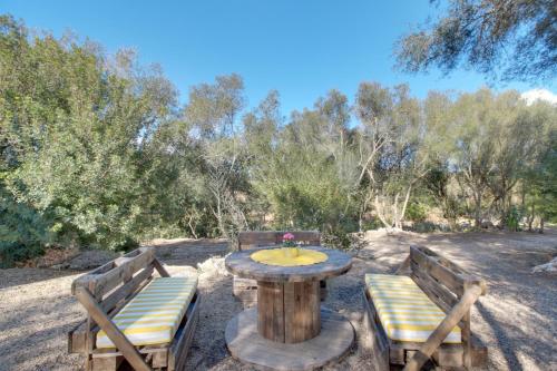 a wooden table with two benches and a table and chairs at Finca S'Erissal de Costitx in Costitx