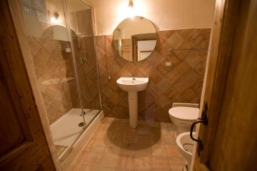 a bathroom with a sink and a toilet and a mirror at Residenza d'Epoca Borgodifiume in Fiumefreddo Bruzio