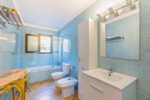Baño azul con aseo y lavamanos en YupiHome Finca Can Lluc, en Alaró