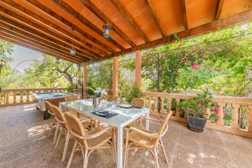 a table and chairs on a porch with a pool table at Finca Can Lluc in Alaró