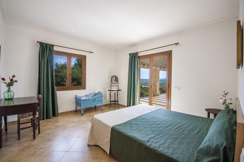 um quarto com uma cama, uma secretária e janelas em YupiHome Finca Son Morei em Vilafranca de Bonany
