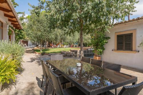 a patio with a table and chairs under a tree at Finca Can Lluc in Alaró