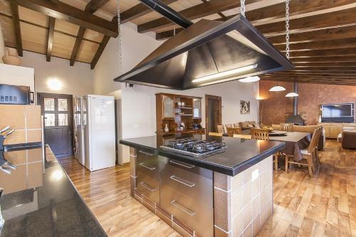 a kitchen with a stove top oven next to a living room at Finca Sa Reconada de L'Ullastre - Family only in Algaida