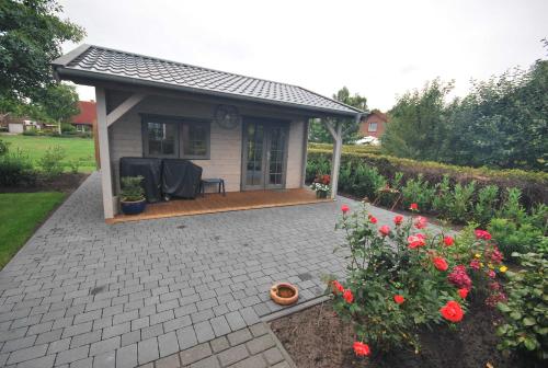 a small house with a patio and flowers at Ferienwohnung Hörnmoor, 35586 in Uplengen