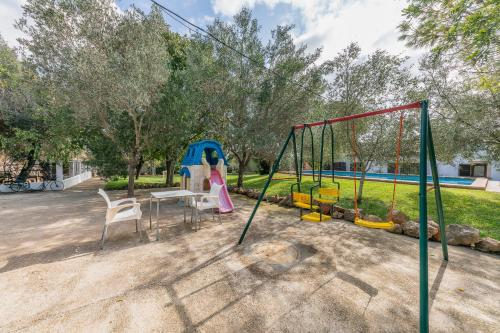 a playground with a slide and a swing at Finca Can Lluc in Alaró