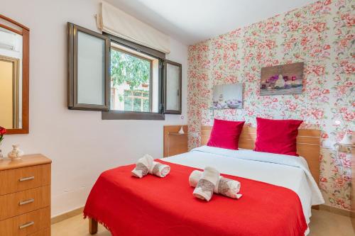 a bedroom with two beds with red pillows at Finca Can Lluc in Alaró