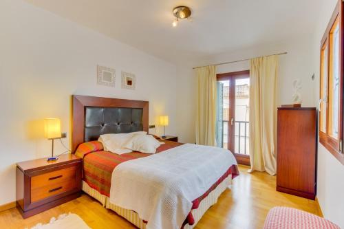 a bedroom with a bed and a dresser with two lamps at Villa Clastra Maria in Maria de la Salut