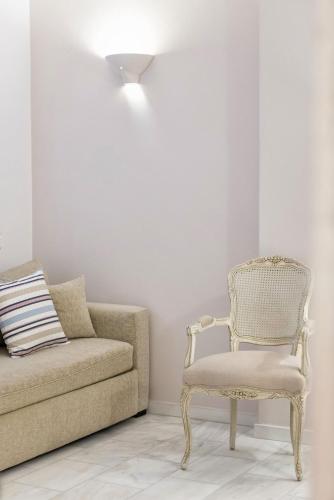 a living room with a chair and a couch at Saint Andrea Seaside Resort - Adults Only in Naousa