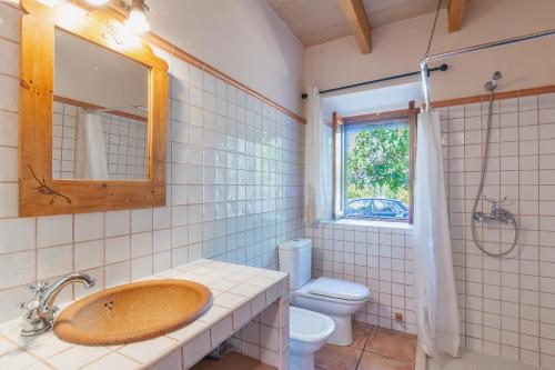 La salle de bains est pourvue d'un lavabo, de toilettes et d'une fenêtre. dans l'établissement YupiHome Finca Sa Casa Nova, à Lloret de Vistalegre