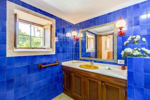 ファラニチュにあるYupiHome Finca Bellpuigの青いタイル張りのバスルーム(シンク、鏡付)