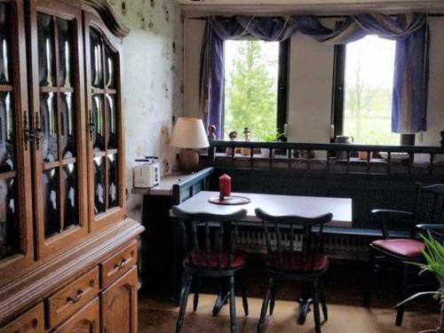 a kitchen with a table and chairs in a room at Ferienwohnung Am Traumgarten, 35646 in Uplengen