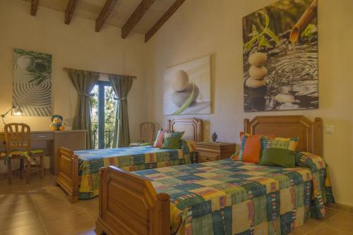 ムロにあるYupiHome Villa Es Moya des Pinsのベッドルーム1室(ベッド2台、テーブル付)