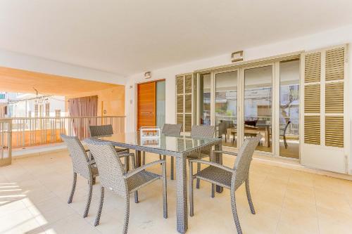 a dining room with a glass table and chairs at Apartment Ca Na Xisca II in Can Picafort