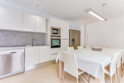 a kitchen with a white table and white cabinets at Apartment Ca Na Xisca II in Can Picafort