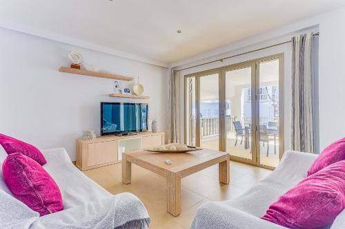 a living room with a couch and a tv and a table at Apartment Ca Na Xisca II in Can Picafort
