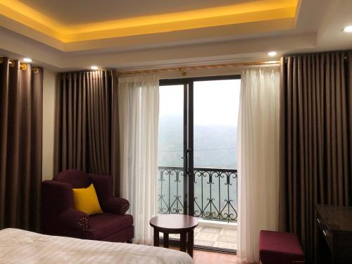 a room with a bed and a chair and a window at Sapa Odyssey Hostel in Sa Pa