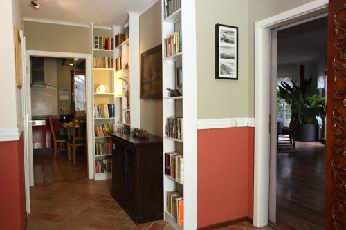 a hallway with book shelves filled with books at Logis Am Park in Dessau