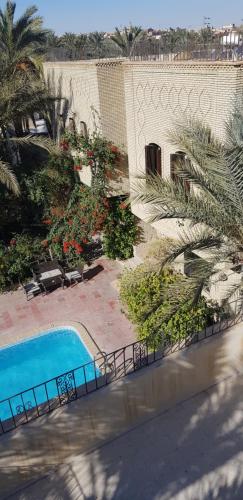 an overhead view of a swimming pool next to a building at Résidence Loued in Tozeur