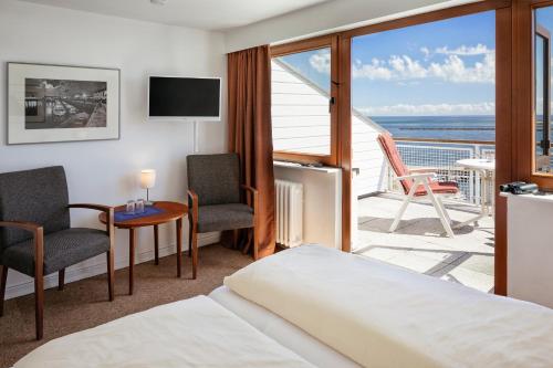 a hotel room with a bed and a balcony at Haus Rooad Weeter in Helgoland