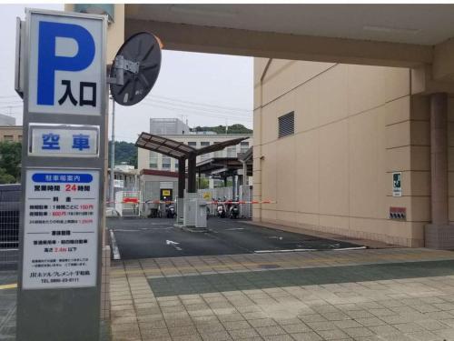a parking sign in front of a gas station at JR Hotel Clement Uwajima in Uwajima