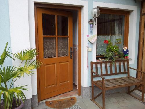 a wooden door with a bench in front of a house at Ferienwohnung Anna Zechner in Flattach