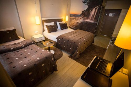 SİVAS HOTEL NEVV في شيفاش: غرفة في الفندق مع سريرين وجهاز كمبيوتر محمول على مكتب