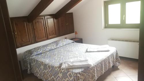 a bedroom with a bed with a blanket and a window at Residence Il Casale in Palinuro