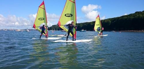 a group of people on sailboards in the water at FSC Dale Fort Hostel in Haverfordwest