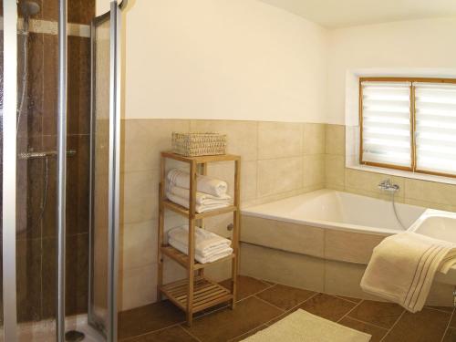 ein Bad mit einer Badewanne, einer Dusche und einem Waschbecken in der Unterkunft Ferienwohnung Bergblick in Filzmoos