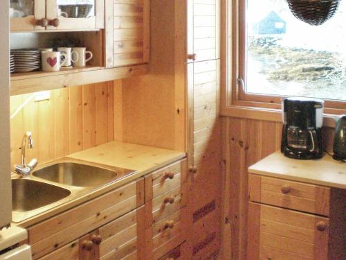 cocina con armarios de madera, fregadero y ventana en Three-Bedroom Holiday home in Nordfjordeid 2, en Heggjafrislia