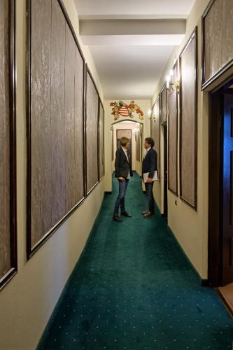 two people are walking down a hallway at Hotel Dwór Polski in Wrocław