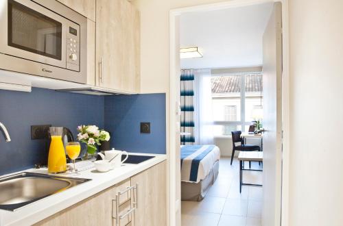 a kitchen with a sink and a bed in a room at Residhome Marseille in Marseille