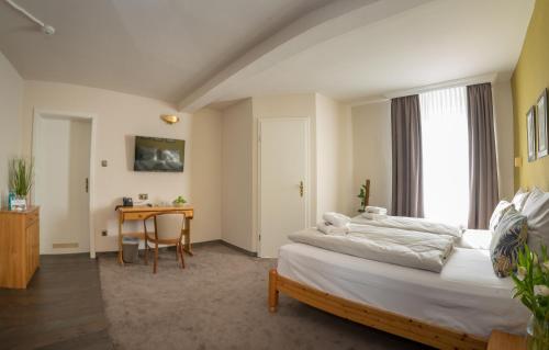 1 dormitorio con cama y escritorio. en Hotel Residenz23, en Weilburg